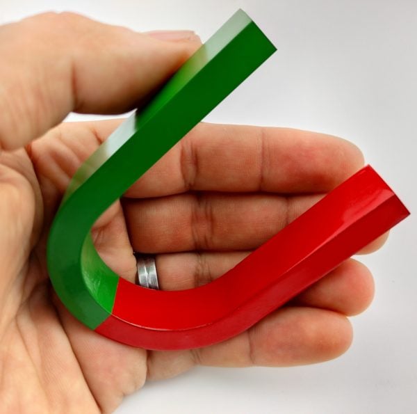 school magnet in hand, magnetic horseshoe, horseshoe-shaped magnet